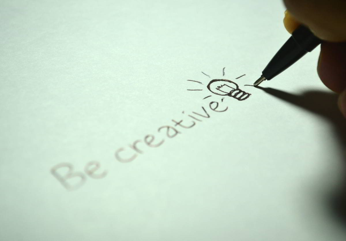 Eine Person schreibt kreativ digitale Geschäftsmodelle auf ein Blatt Papier.